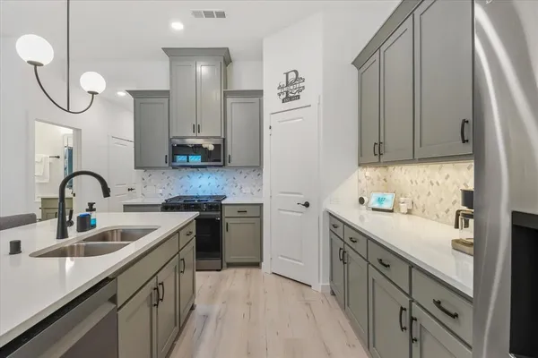 a kitchen with white cabinets a sink and dishwasher
