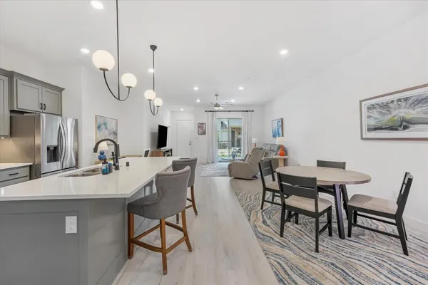 a kitchen with stainless steel appliances kitchen island a dining table and chairs