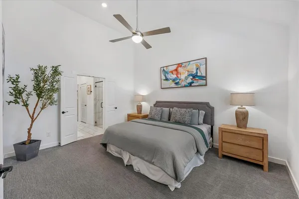 a spacious bedroom with a bed and a potted plant