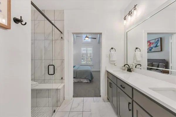 a spacious bathroom with a double vanity sink a mirror and a shower