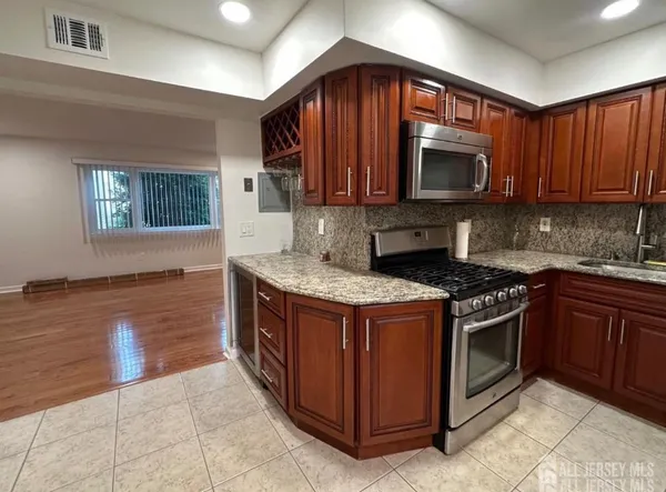 a kitchen with stainless steel appliances granite countertop a stove a sink and a microwave
