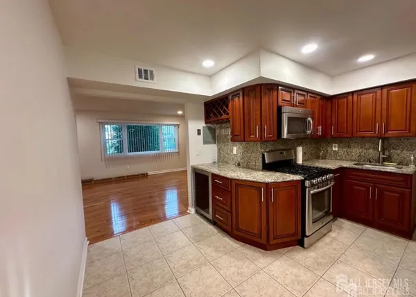 a kitchen with stainless steel appliances granite countertop a stove a sink and a microwave