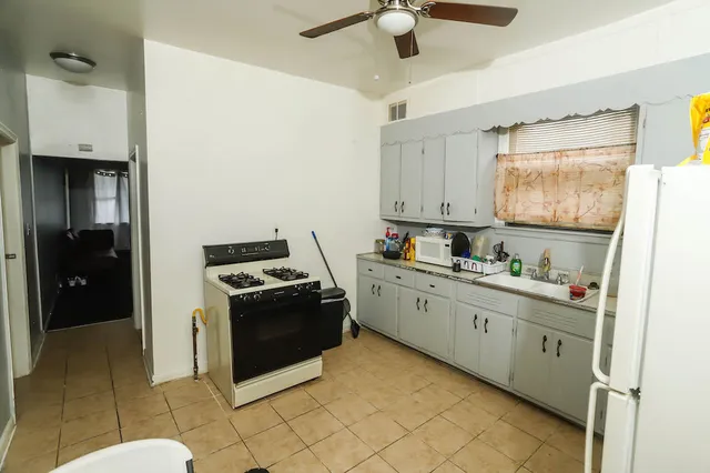 a kitchen with stainless steel appliances granite countertop a stove a sink and a refrigerator