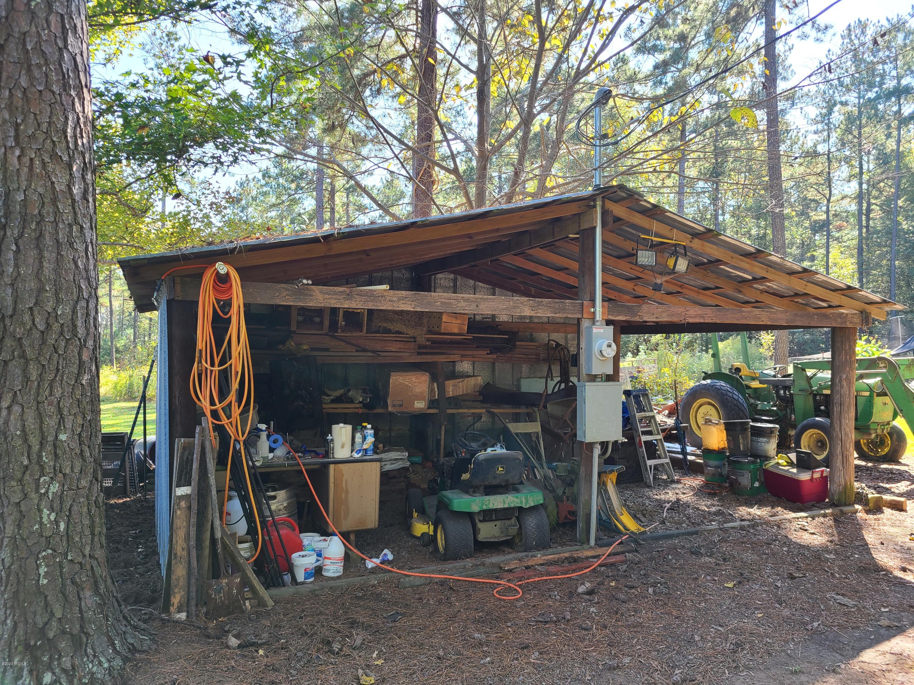 1172 Cumslo Road Macon, GA 31211 - Photo 17 of 33 a view of a garage with a table and chairs under an umbrella