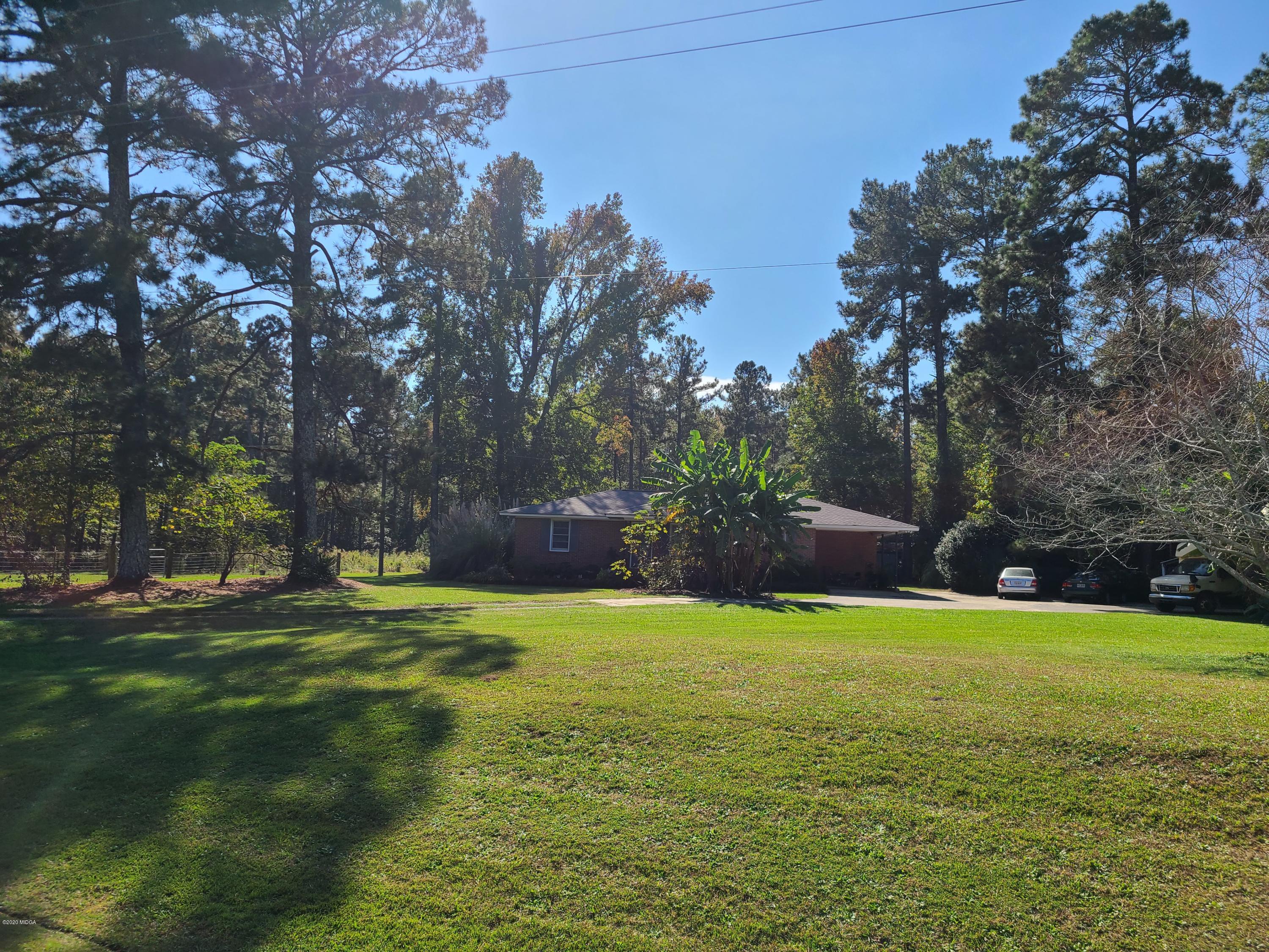 1172 Cumslo Road Macon, GA 31211 - Photo 3 of 33 a view of a grassy field with trees in the background