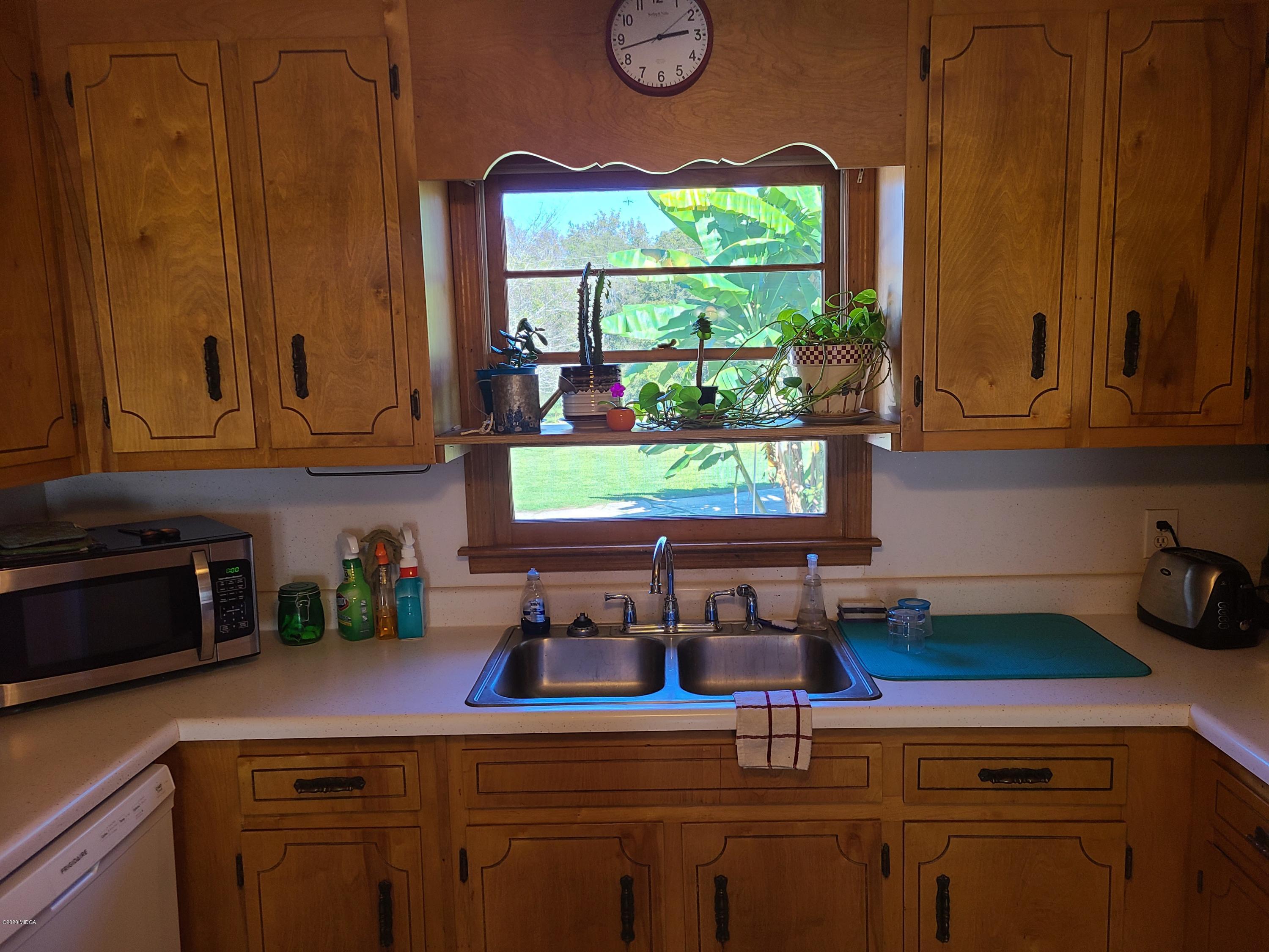 1172 Cumslo Road Macon, GA 31211 - Photo 23 of 33 a kitchen with stainless steel appliances granite countertop a sink a stove and next to a window