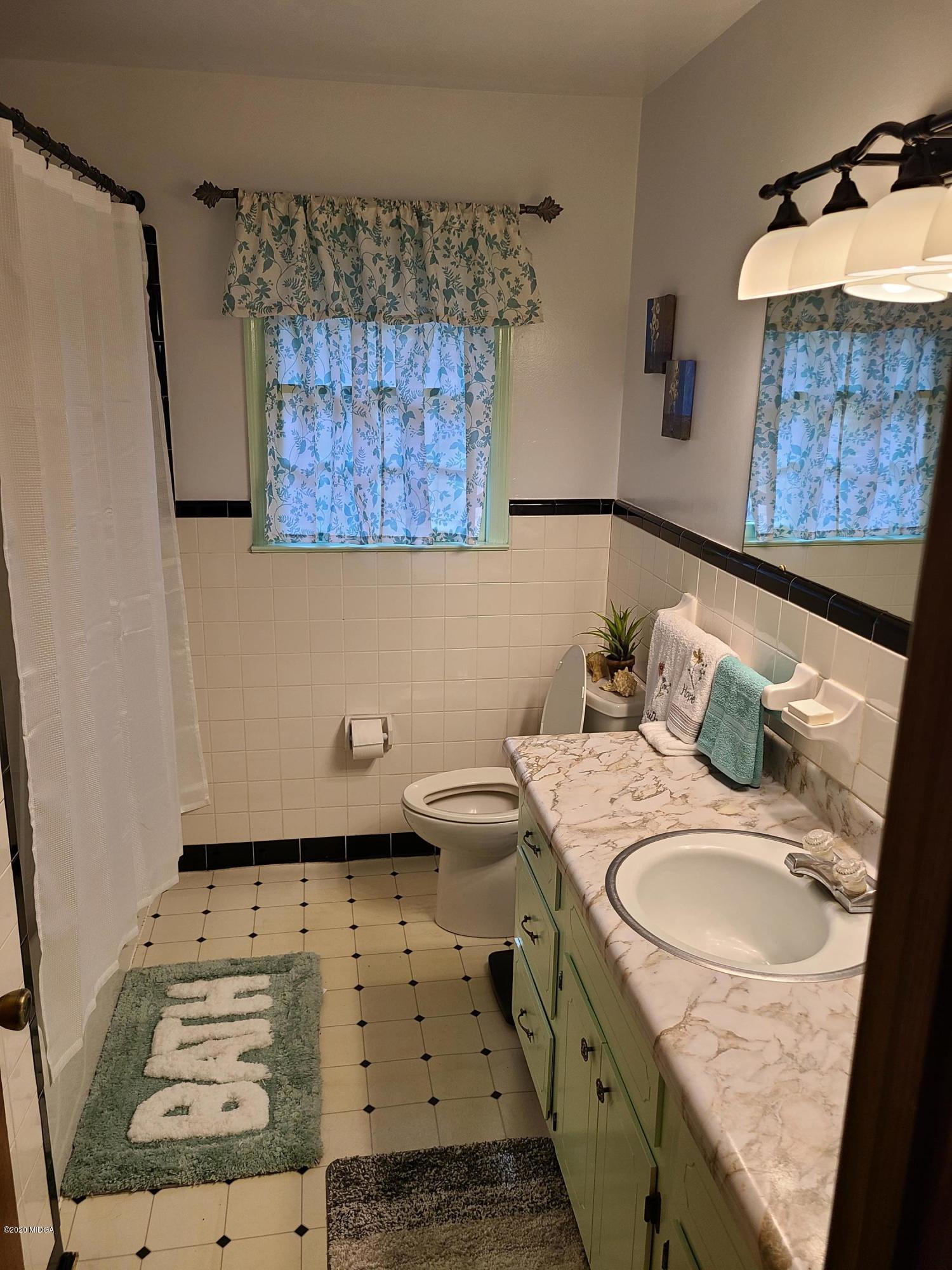 1172 Cumslo Road Macon, GA 31211 - Photo 33 of 33 a bathroom with a sink stove and mirror