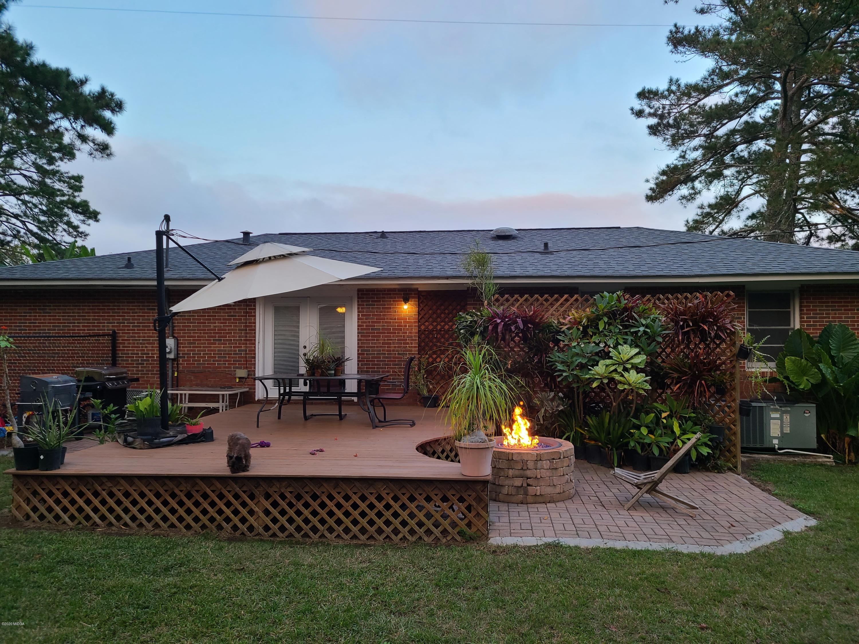 1172 Cumslo Road Macon, GA 31211 - Photo 5 of 33 a view of a patio with table and chairs potted plants and a large tree