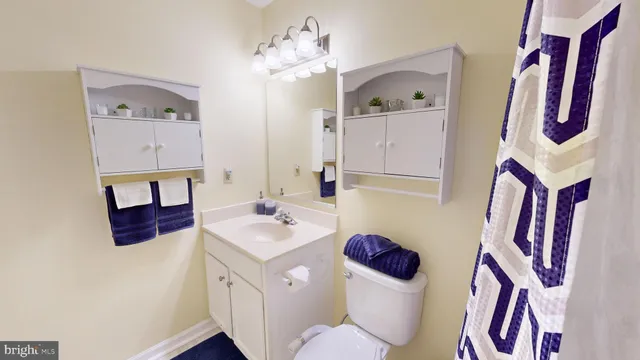 a bathroom with a sink vanity mirror and toilet