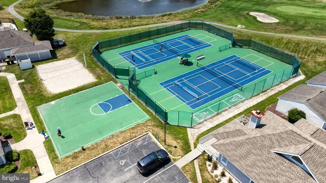 an aerial view of a tennis ground and a cars park
