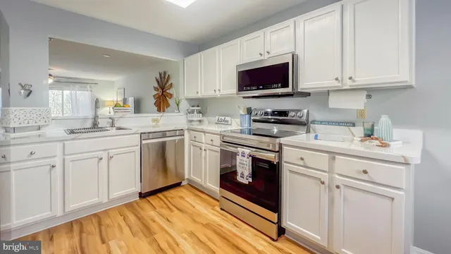 a kitchen with white cabinets stainless steel appliances and sink