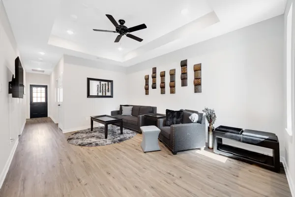 a living room with furniture and a wooden floor