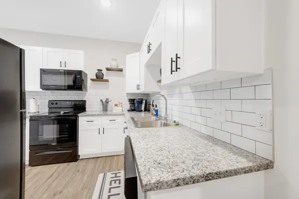 a kitchen with stainless steel appliances granite countertop a sink stove and refrigerator