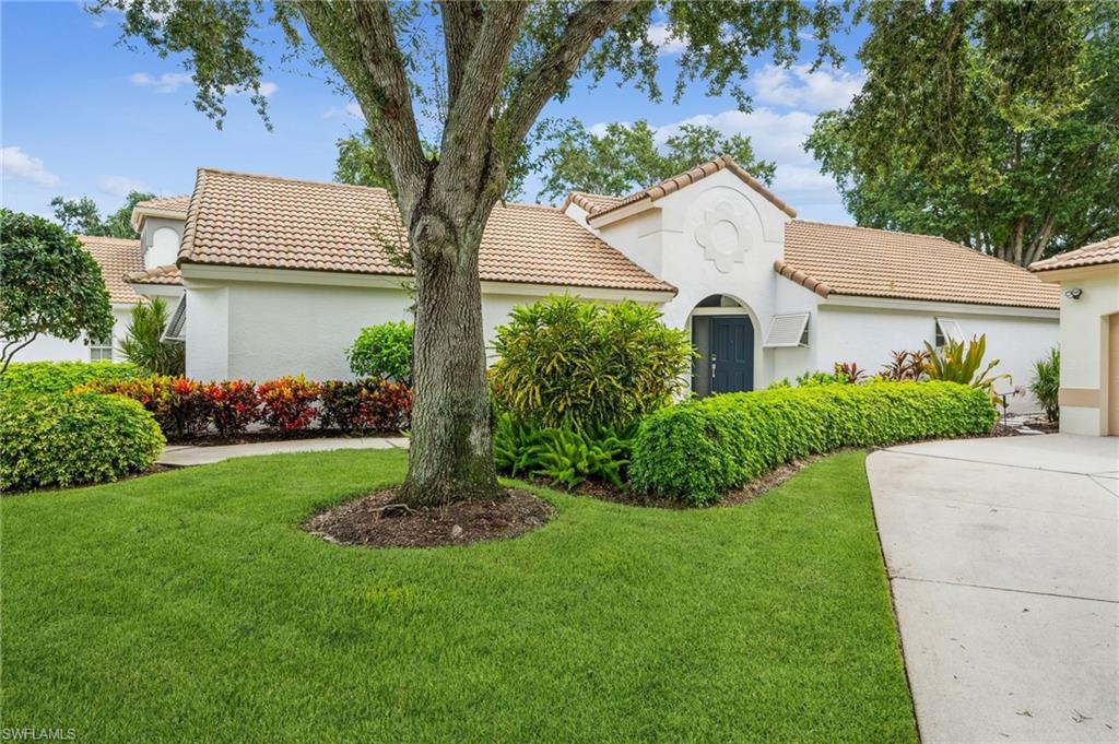 159 San Rafael Lane Naples, FL 34119 - Photo 2 of 20 a front view of a house with a garden and plants