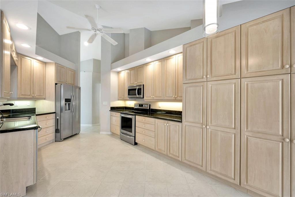 159 San Rafael Lane Naples, FL 34119 - Photo 6 of 20 a kitchen with white cabinets and stainless steel appliances