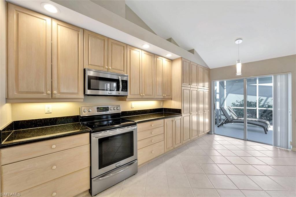 159 San Rafael Lane Naples, FL 34119 - Photo 7 of 20 a kitchen with granite countertop a stove a sink and a refrigerator