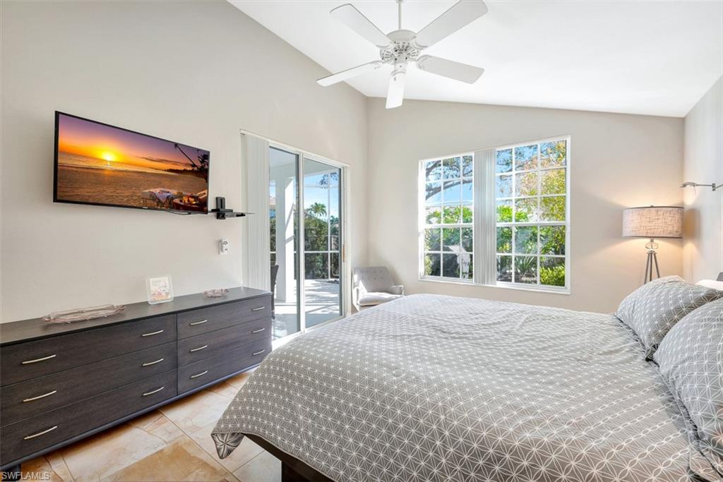 159 San Rafael Lane Naples, FL 34119 - Photo 10 of 20 a bedroom with a large bed and a flat tv screen on dresser