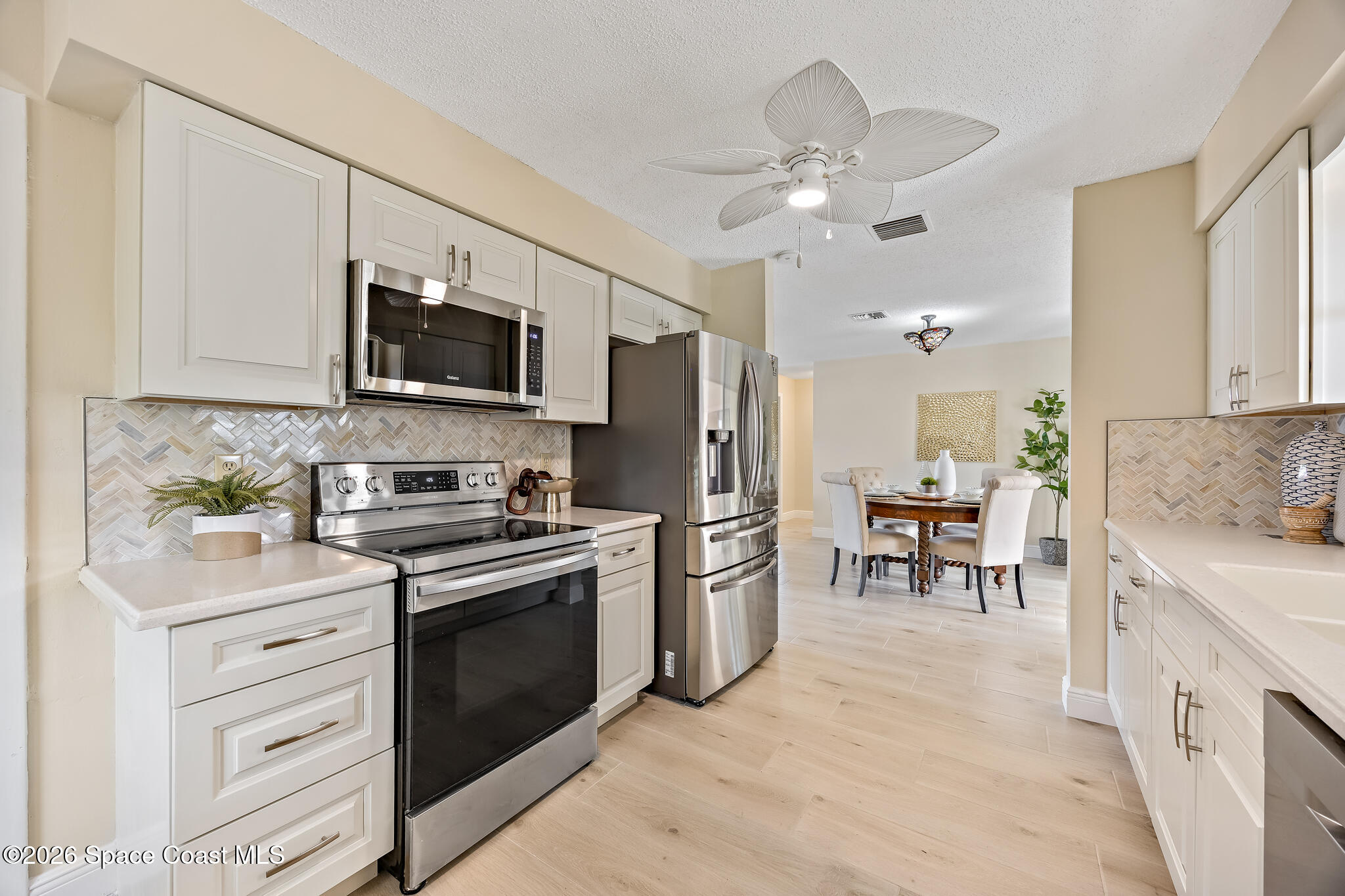 180 Concha Drive Sebastian, FL 32958 - Photo 31 of 32 a kitchen with stainless steel appliances a stove refrigerator sink and microwave