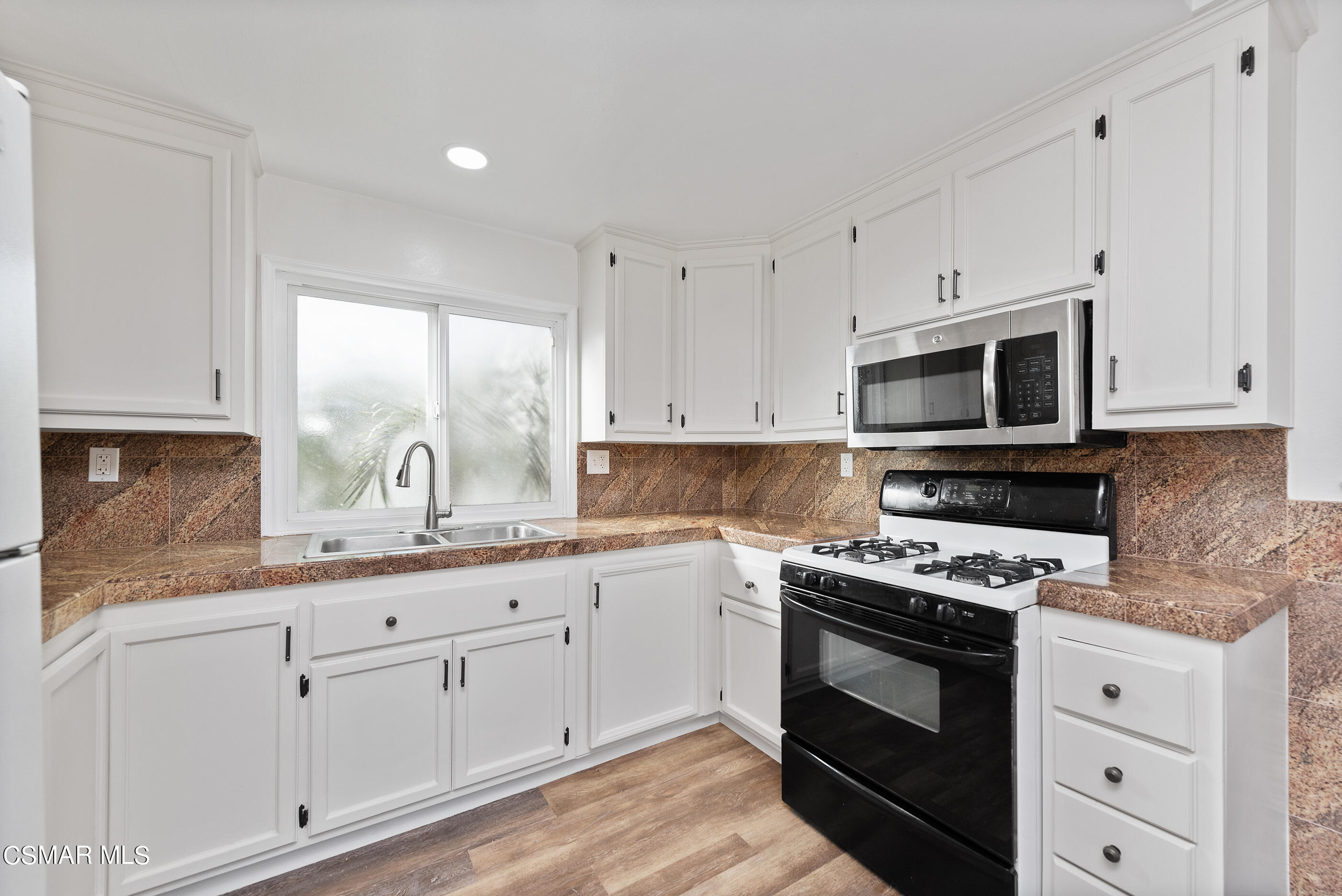 2181 Rhoda Street Simi Valley, CA 93065 - Photo 12 of 36 a kitchen with granite countertop white cabinets appliances and a window