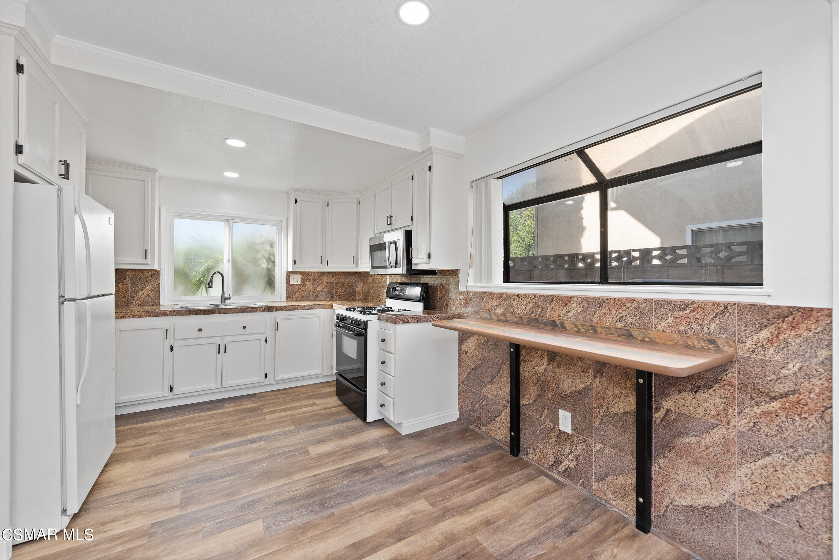 2181 Rhoda Street Simi Valley, CA 93065 - Photo 10 of 36 a kitchen with a sink window and stainless steel appliances