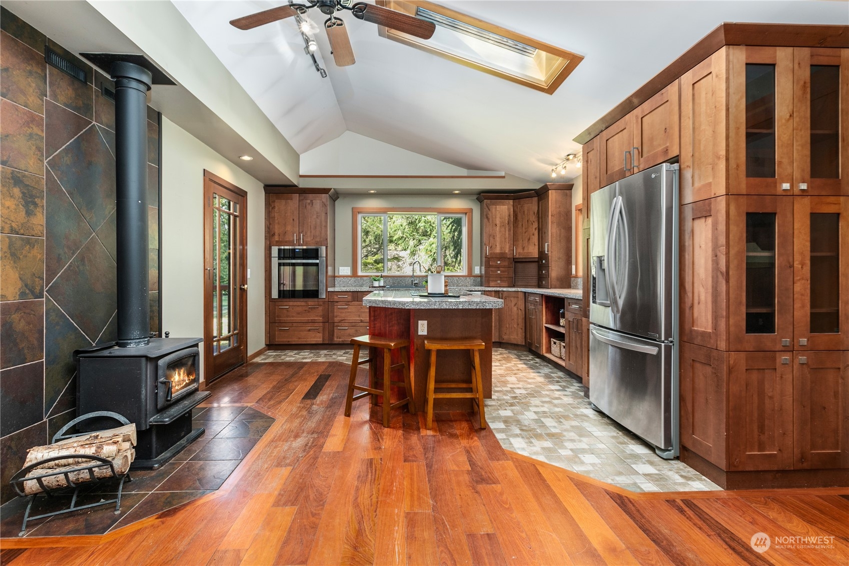 3193 Behme Road Custer, WA 98240 - Photo 6 of 33 a kitchen with stainless steel appliances granite countertop a refrigerator a sink dishwasher a stove and a dining table with wooden floor