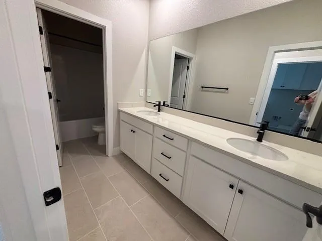 a spacious bathroom with a double vanity sink and mirror