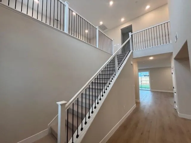 a view of staircase with railing and a window