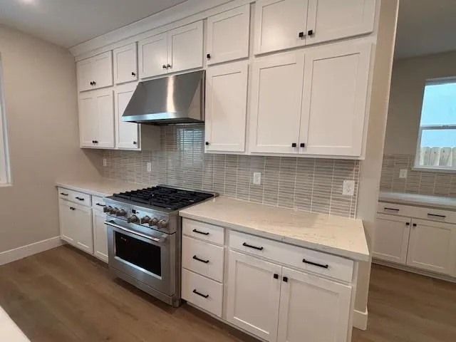 a kitchen with granite countertop white cabinets and white appliances