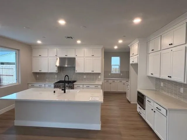 a kitchen with stainless steel appliances sink refrigerator and cabinets