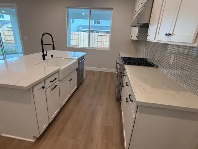a kitchen with a sink stove and cabinets