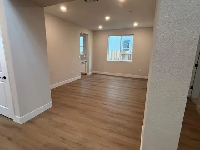an empty room with wooden floor and windows