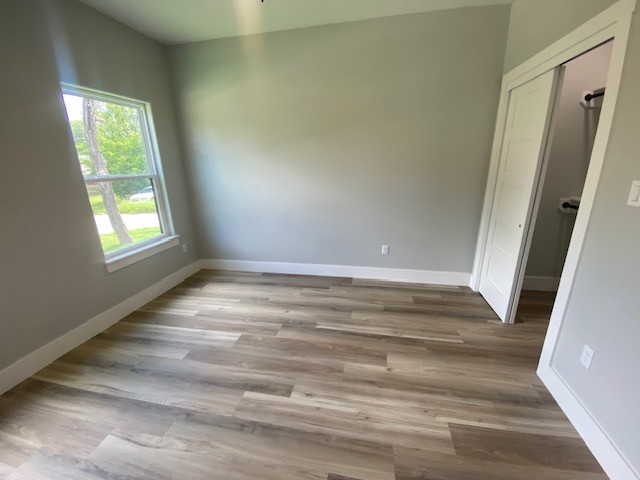 116 Field Street Luling, TX 78648 - Photo 24 of 33 Well-lit living area featuring rich hardwood flooring and convenient closet access.