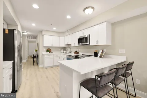 a kitchen with white cabinets and stainless steel appliances