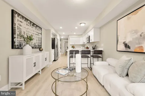 a living room with furniture and kitchen view