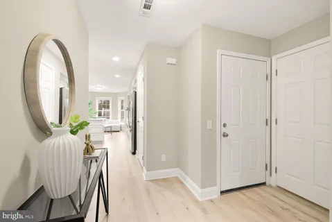 a view of a hallway with wooden floor windows and a kitchen
