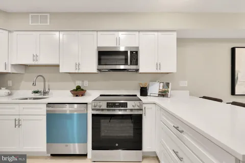 a kitchen with stainless steel appliances granite countertop a sink a stove and microwave