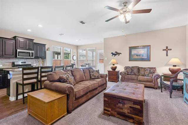 a living room with furniture a flat screen tv and kitchen view