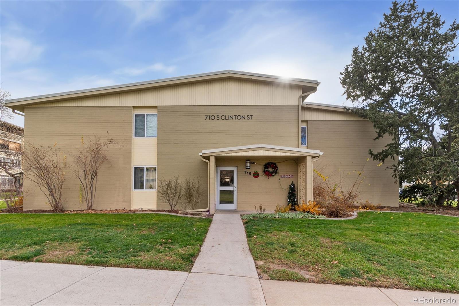 710 South Clinton Street, Unit 6B Denver, CO 80247 - Photo 16 of 31 a view of a house with a small yard and a large tree