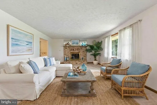 a living room with furniture fireplace and a large window