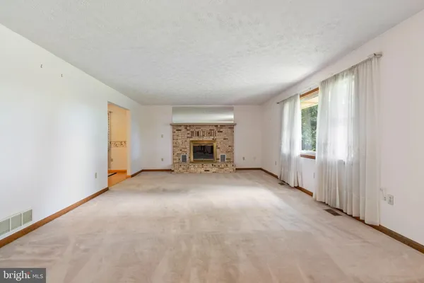 an empty room with windows and fireplace