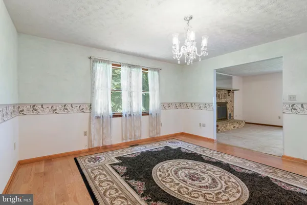 a view of a bedroom with wooden floor and a chandelier