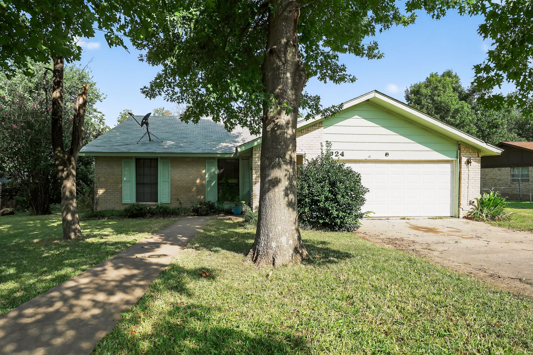 324 McClendon Drive Elgin, TX 78621 - Photo 1 of 1 Ranch-style home featuring brick siding, a front lawn, driveway, and an attached garage