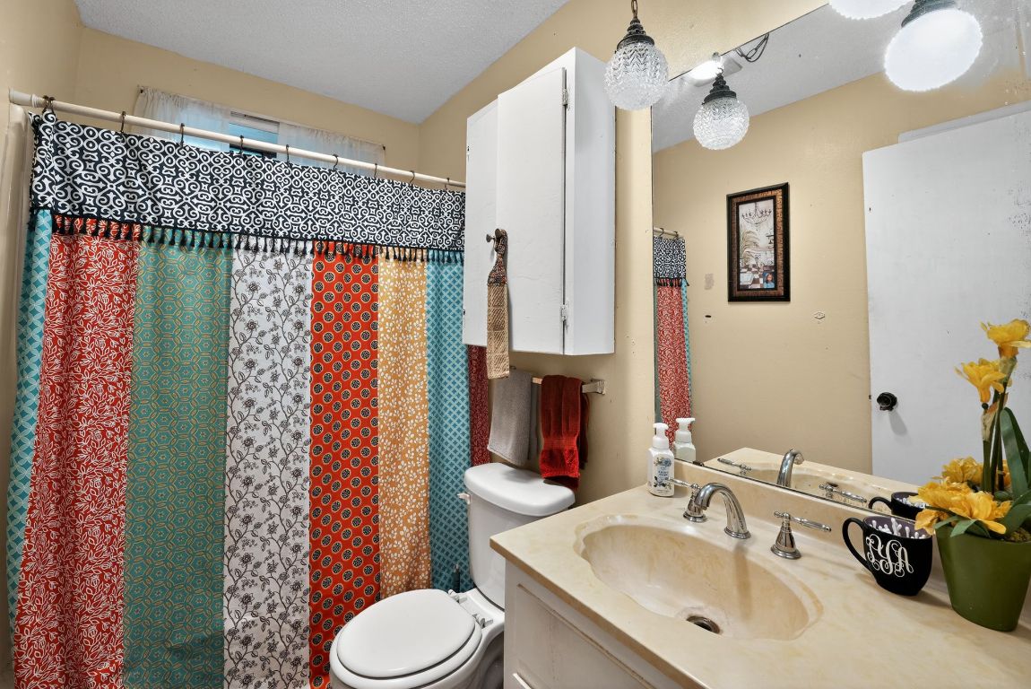 324 McClendon Drive Elgin, TX 78621 - Photo 4 of 16 a bathroom with a sink toilet and shower