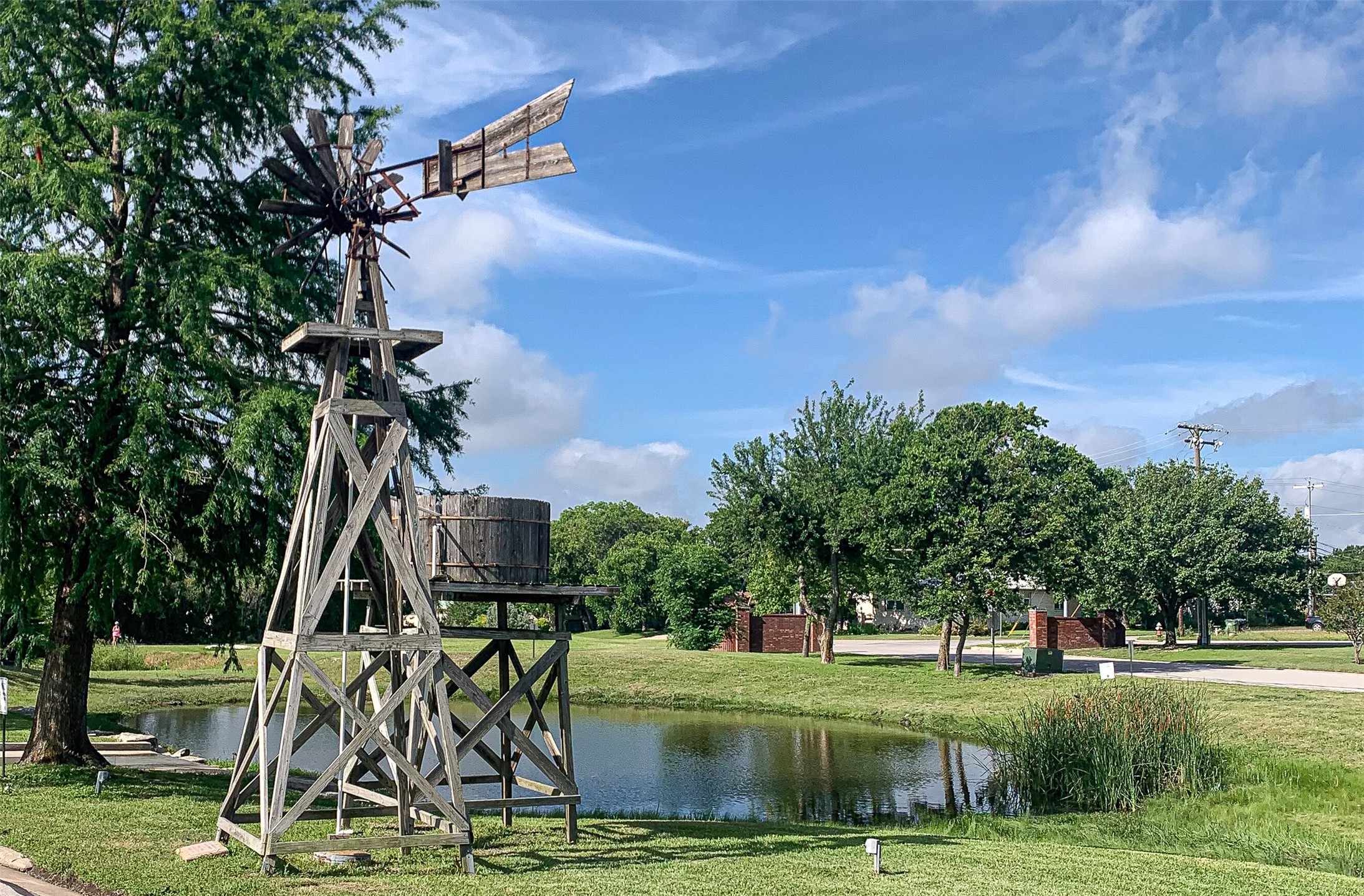 316 Pepper Mill Loop Burnet, TX 78611 - Photo 27 of 27 A picturesque pond complements a classic wooden windmill under an open sky, offering tranquil views.