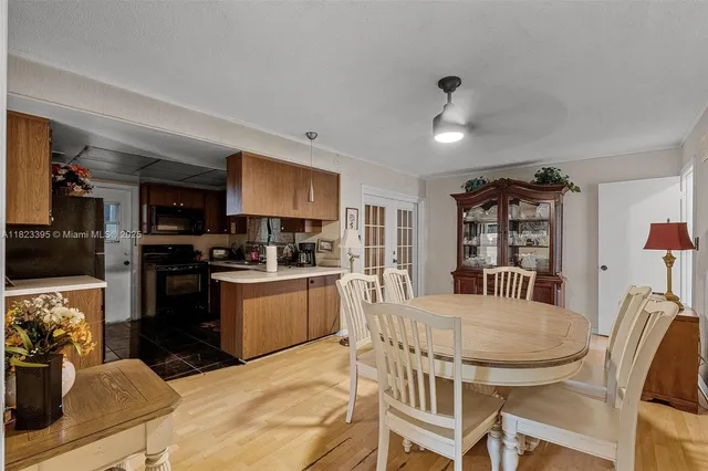 a kitchen with granite countertop stainless steel appliances a sink dining table and chairs