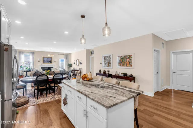 a view of a dining room and livingroom with furniture wooden floor a chandelier