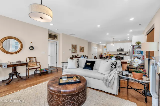 a living room with furniture kitchen view and a mirror