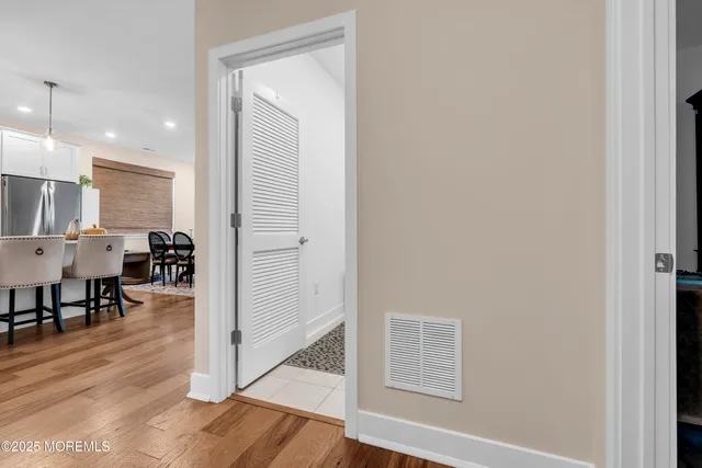 a view of a hallway with wooden floor windows and a dining room