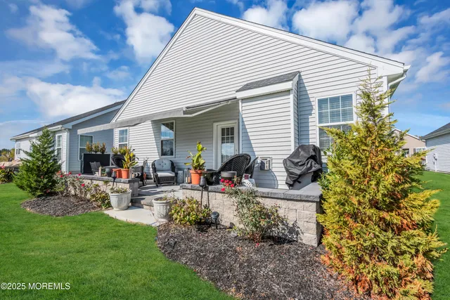 a view of a house with backyard and sitting area