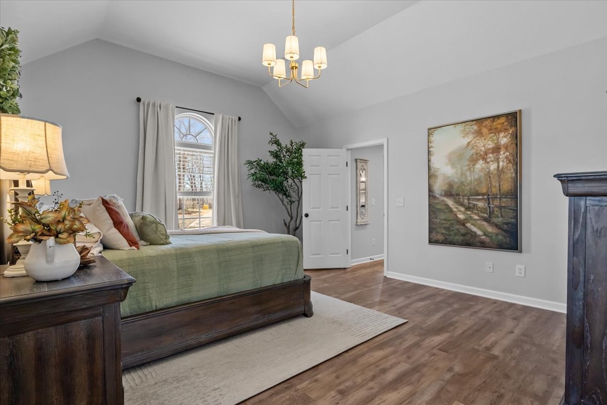 7327 Hunting Camp Road Fairview, TN 37062 - Photo 24 of 83 a spacious bedroom with a bed and a chandelier